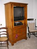 Vintage cane seat chair, Thomasville oak entertainment center with TV and VCR, Hitchcock-style rocking chair (black with gold stencil)