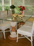 Double pedestal base glass top table with 6 wicker chairs.  On top: Watt pottery bowls