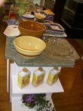 View of the kitchen island with bowls, and other decorative ceramic & glass items