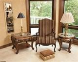Striped arm chair w wood carving in arms and legs, footstool w trim, glass top round table w detail under glass