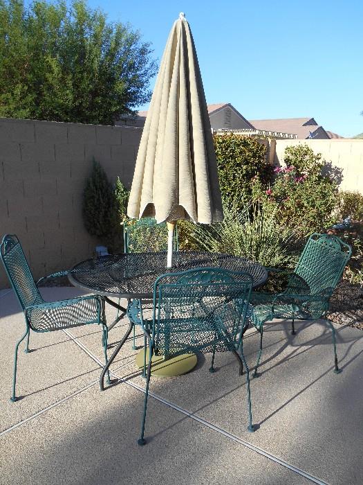 Perfect for high wind areas, this wrought iron patio set and umbrella are versatile and elegant.