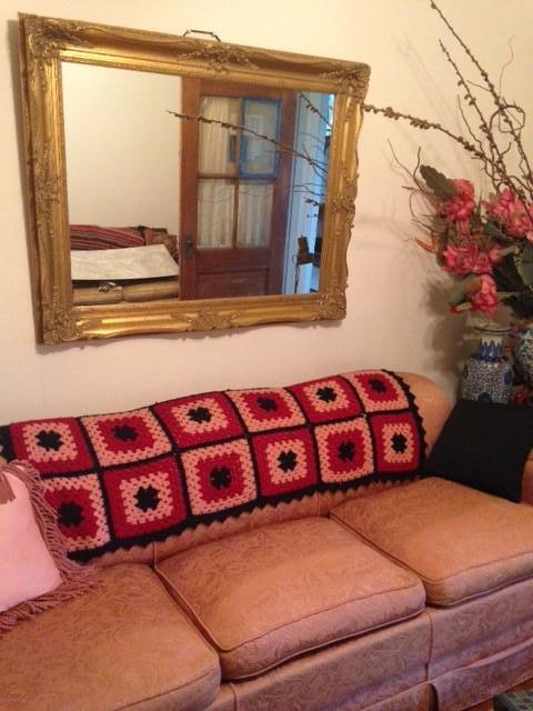 Vintage down-stuffed sofa and Hollywood Regency gold mirror. Second floor.