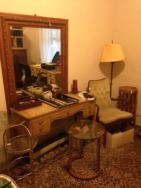 Vintage vanity, mirror, antique chair, end tables, lamp, wicker plant stand. Second floor.