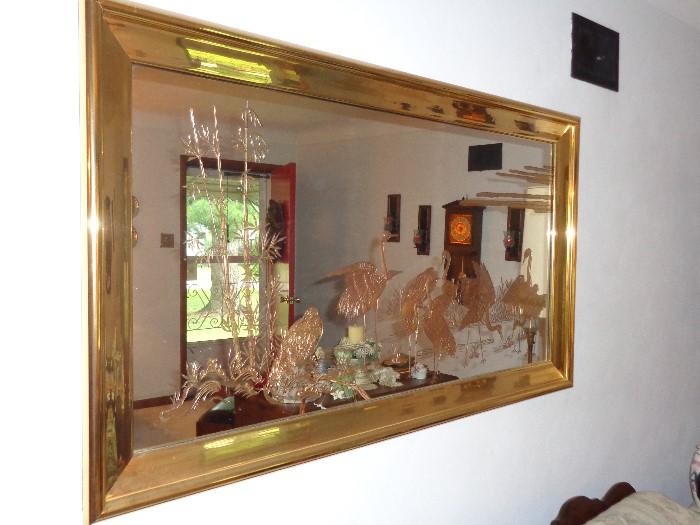 Gold tone metal framed mirror with etched birds. Approximately 48 wide and 36 inches tall.