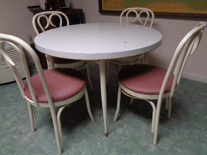 White round Formica table with 4 matching soda fountain style chairs.  Rose colored vinyl seats.