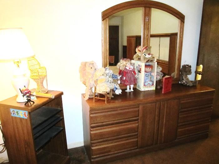 Modern Style Triple Dresser with  Double Mirror, and rich finish,  6 drawers and center cabinet door storage; (Triple Dresser is matching to other bedroom furniture shown elsewhere in this collection). Stereo Cabinet with shelves storage;  Accent Table Lamp is available as are the collection of dolls and other items pictured. 