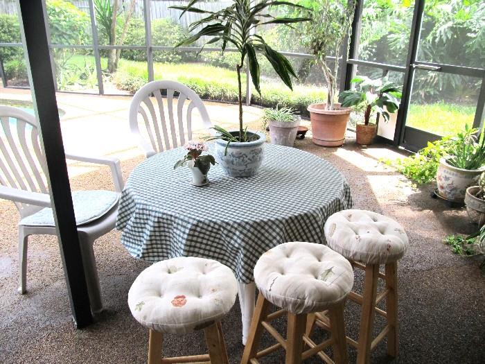 Patio Set...Round Patio Table with two chairs;  Also shown are three wood bar stools with light finish and tufted cushion seats; Also shown are potted plants and decorative pots that are also available