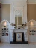 Living Room: The built in bookcases contain classic décor; the mantel has floral topiaries; and the hearth holds a large SALVADOR DALI signed piece of art.