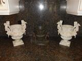 Kitchen Hall:  One black metal urn is in the middle and is flanked by two stone cherub urns--each is priced separately.