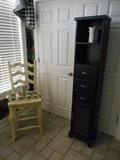 Laundry Room:  Off-white armless chair; green porcelain tea service on gold tray; tall narrow black cabinet.