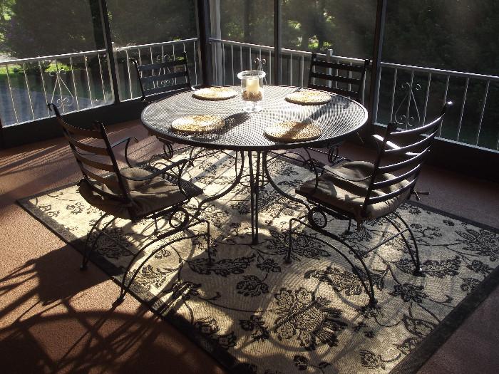 Very comfortable wrought iron table and chairs, new condition, resting on a beautiful Turkish Rug by Safavieh .