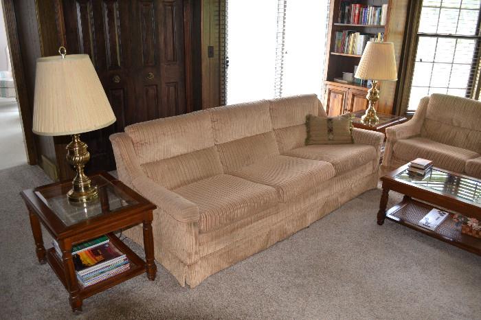 Twin gold sofas, glass top end tables, brass lamps, great accents for den or family room.
