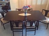 This mid century table has been painted black, but it has four leaves and expands to fit a large gathering!