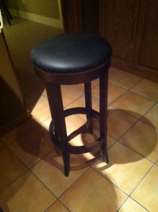 One of three leather topped stools from Pottery Barn for sale