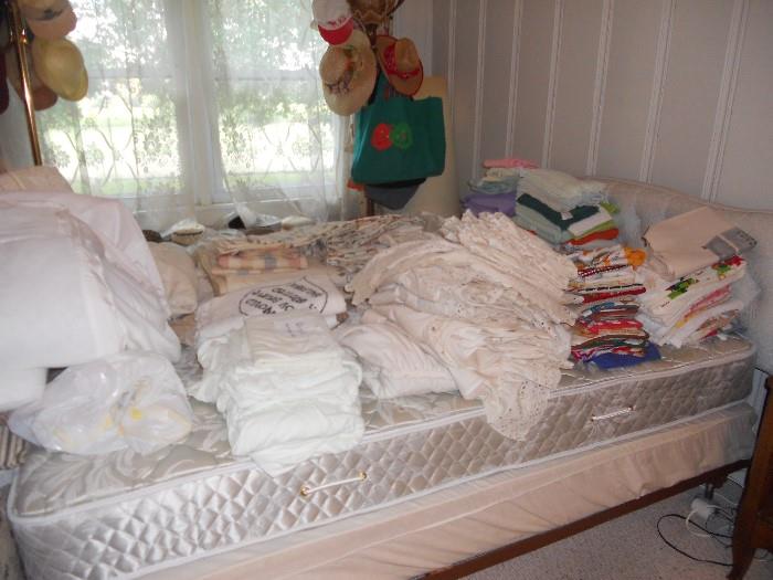 Lots of linens, curtains, kitchen towels, napkins and tablecloths