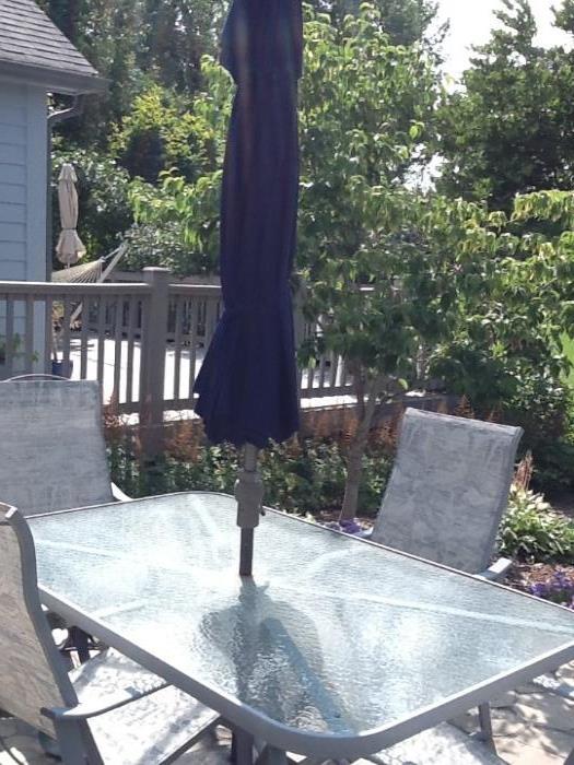 Glass Patio table with 4 arm chairs, navy umbrella and stand