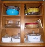 Various kitchen bowls, grater, colander, Pyrex baking dishes and lids, bundt, cutting board, baking dishes.
