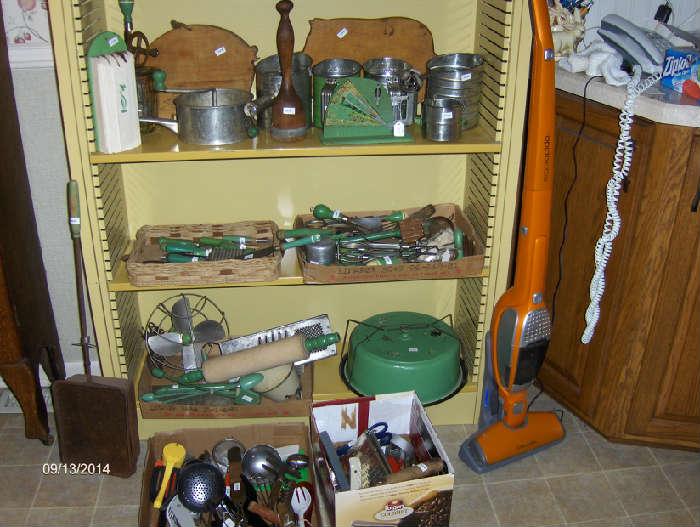 Lots of green handled kitchen utensils