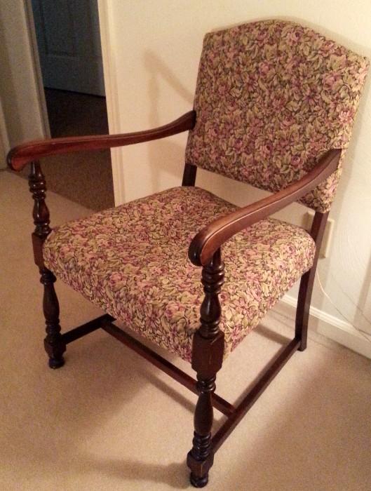 One of two vintage chairs with a rose pattern fabric.