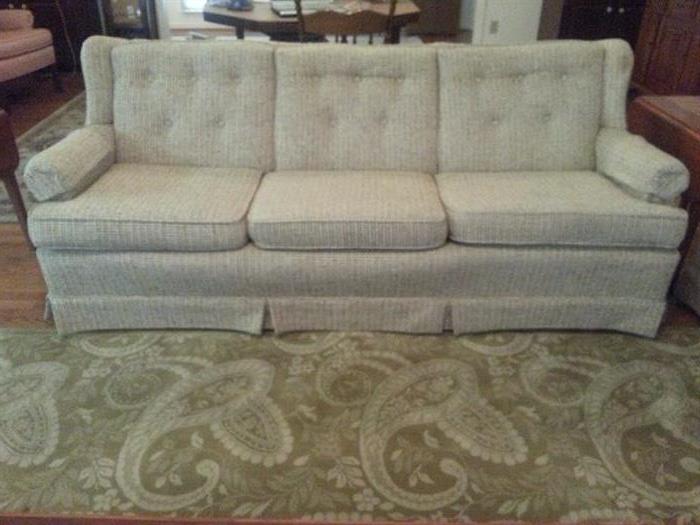 Off white sofa in good condition shown with the contemporary room side rug.