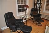 Black leather chairs with ottomans and a chrome mirrored side table