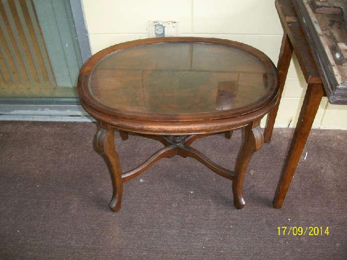 Small wood table with wood trimmed glass tray top.