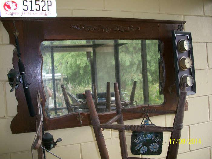 Wood wall mirror with hooks.