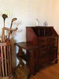 Vintage gold clubs. Vintage canes. Newspaper stand. Secretary desk.