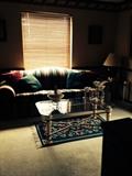 sleeper sofa and a pair of glass top tables and coffee table