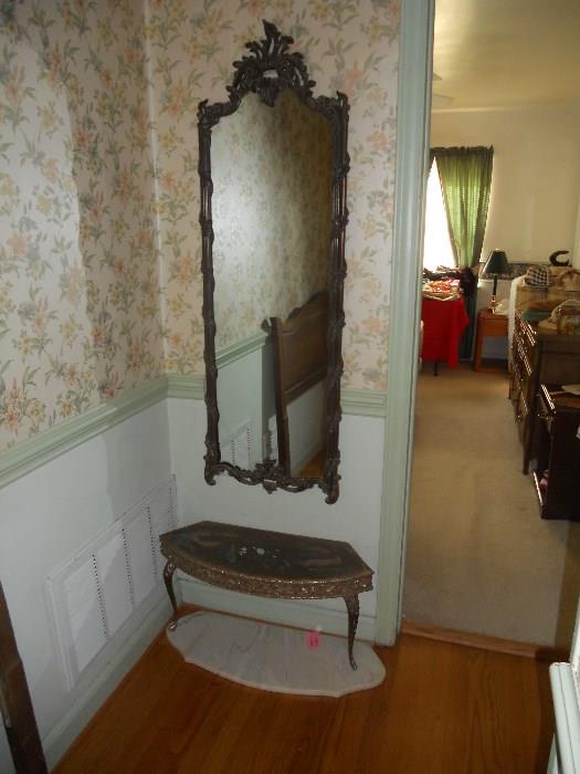 Ornate mirror with curved table below--marble top for table is on floor