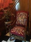 One of two needlepoint chairs; small marble top table & arrangement