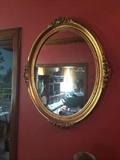 Gold oval mirror;