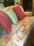 Elephant-print love seat; decorative pillows;