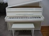 Contemporary White Yamaha upright piano with bench.