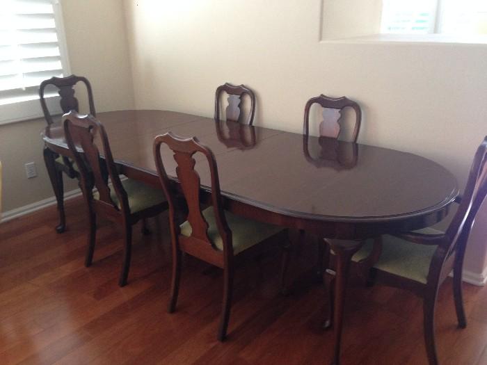 Queen Anne style dark wood table with three leaves and six chairs