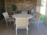 Patio table and four chairs.Grill, park bench back wall.