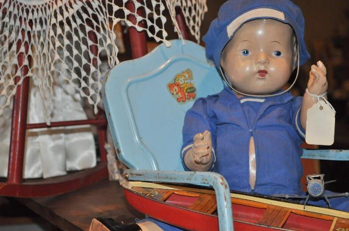 Cutest little boy doll ever holding a Wyandotte boat and chillin' in an old metal rocker.