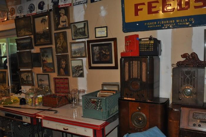 Really nice framed artwork, a couple of nice enamel-topped tables (one missing a drawer), more picture frames, a few old radios...