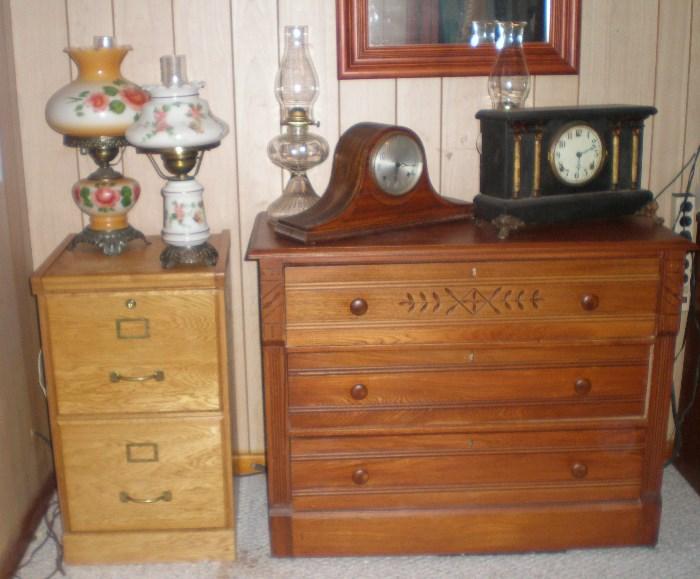 Wood file cabinet with two glass hand painted lamps (SOLD), 3 drawer chest with two oil lamps (sold), hump back clock and mantel clock (available).
