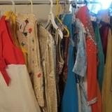 ONE OF THREE RACKS OF SEQUINED SHOW GOWNS