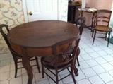 Walnut round table and six Walnut chairs