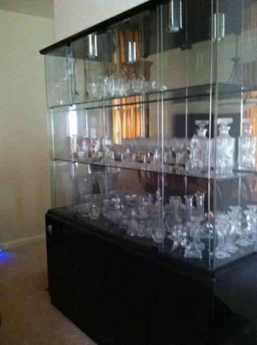 Modern black retro, contemporary china cabinet with lighting. Lots of glassware, crystal, cut and old glassware.