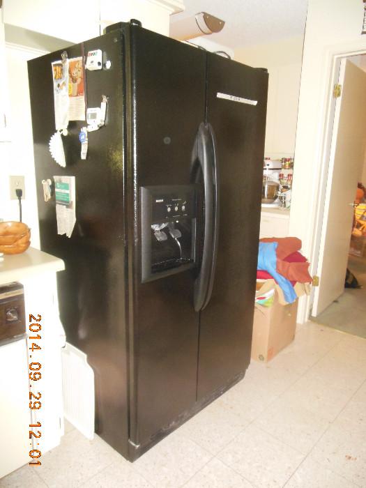 Black Kenmore double door refrigerator with ice and water in door.