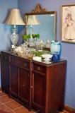 Hallmark Quality Furniture buffet, vintage crystal lamp, antique mirror, vintage framed print, Polish glass vases, Waterford crystal bowls, vases and Jesus bust, milk glass, vaseline glass, espresso cup/saucer set, vintage cigarette box, teapot, depression glass bowls and dishes.