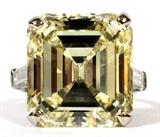 Lot#2029, 20.08 CT. FANCY NATURAL YELLOW EMERALD CUT DIAMOND & PLATINUM RING, VS2, GIA CERTIFIED.Prong set emerald cut diamond, measuring 16.72 x 15.35 x 9.39 mm; weight of 20.08 ct.; VS2 clarity.  Also two bar set baguettes approx. weight of 1.20 ct.  Platinum setting weight 5.7 gr.  Ring size 4.5. Bidders on this lot must register at our auction office. Bidding will be by approved flat bid, audience participation by prior approval or by telephone with proper accreditation. Preview by appointment. No internet bidding on this lot