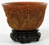Lot#2231, CHINESE HORN LIBATION CUP, H 2.75", DIA 4.75"Featuring genre scenes in relief.  Accompanied by a stand.