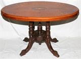 Lot#2315, MARQUETRY INLAID OVAL WALNUT TABLE, C. 1930, H 21" L 34" D 20"Raised on a four legged pedestal base, decorated in satinwood marquetry inlay along the top. Measuring H. 21" x 34 3/8" x 20", circa 1870. From the collection of Irene Walt, Huntington Woods, Michigan.