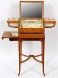 Lot#1001, ENGLISH PEAR WOOD FITTED VANITY TABLE, C. 1914, H 33", W 14", D 11 1/2"A hinged and compartmented vanity table with interior label which reads "Mappin & Webb, 158.162 Oxford St. W.", London (see additional photo). Includes 2 glass bottles and 1 oblong bowl with English sterling silver rims, 1 round bowl, 18 vanity accessories including scissors, nail file, cuticle remover, etc., many with celluloid handles.  English sterling hallmarks include a lion passant, uncrowned leopard and date letter "S" indicating London, 1913-14, and maker's mark for George Betjeman & Sons (see additional photo).