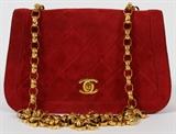 Lot#1487, CHANEL QUILTED RED SUEDE SHOULDER BAG, W 8"A single flap at the front and exterior pocket at the reverse, with a  logo turnlock opening to a red leather lined interior fitted in two sections, stamped, "Chanel, Made in France" in gold. Measures W. 8" x 5", L. 20" to the shoulder strap. Includes a matching coin purse, measuring H. 3 3/8" x 4 3/4".