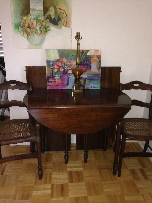 Cherry drop leaf table, vintage chairs, owner's artwork